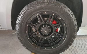 Image shows the front wheel of a car at Racers Paint and Panel with Wheel Customisation painted Calipers in red, painted rims