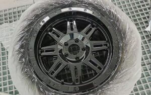 Image shows Mag Rim after repray in the paint booth with a black finish - Wheel Rim Respray. Racers Paint and Panel