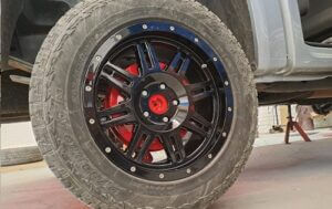 Image shows the back wheel with high gloss black rim respray and brake calliper Customisation at Racers Paint and Panel