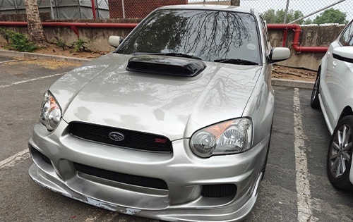 Image shows a subaru parked outside racers paint and panel before full car respray